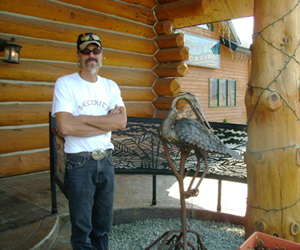 Al Derber next to bird sculpture